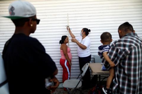 A Central American migrant, moving in a caravan through Mexico and traveling to request asylum in U.S, checks her health status as she arrives to Mexicali, Baja California state, Mexico, April 25, 2018. PHOTO BY REUTERS/Edgard Garrido
