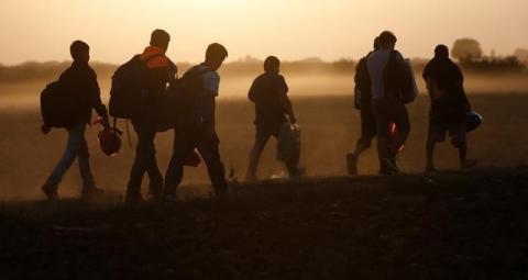 Migrants walk on a dirt road as they approach the Croatian border near the town of Sid, Serbia, September 18, 2015. PHOTO BY REUTERS/Stoyan Nenov