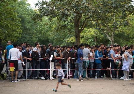 Newly arrived migrants wait in front of the State Office for Health and Social Affairs to apply for asylum in Berlin, Germany, August 11, 2015. PHOTO BYREUTERS/Stefanie Loos