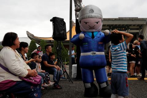 A performer dressed in a military honour guard mascot costume dances during a public fair which displays military equipments, in Taipei, Taiwan, September 29, 2018. PHOTO BY REUTERS/Tyrone Siu