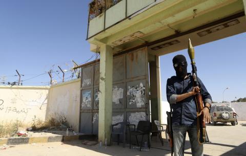 A militia stands guard in front of the entrance to the February 17 militia camp after Libyan irregular forces clashed with them in the eastern city of Benghazi