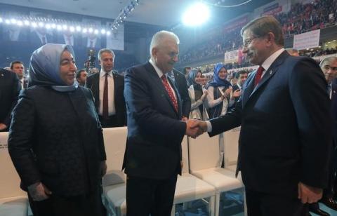 Transportation Minister Binali Yildirim (C), accompanied by his wife Semiha Yildirim (L), shakes hands with Turkey's outgoing Prime Minister Ahmet Davutoglu during the Extraordinary Congress of the ruling AK Party (AKP) to choose the new leader of the party, in Ankara, Turkey, May 22, 2016. PHOTO BY REUTERS/Riza Ozel