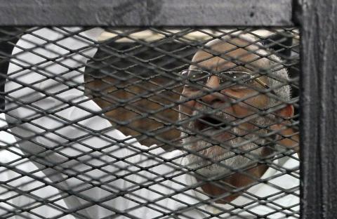 Muslim Brotherhood leader Mohammed Badie shouts slogans from the defendant's cage during his trial with other leaders of the Brotherhood in a courtroom in Cairo