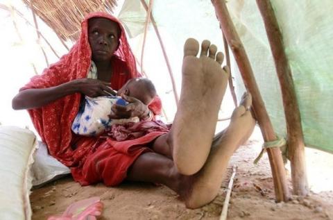 An internally displaced woman feeds her child inside their makeshift shelter structure at the Qansahaley settlement camp in Dollow town along the Somalia-Ethiopia border, August 30, 2011. PHOTO BY REUTERS/Thomas Mukoya