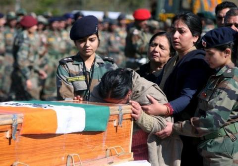 The mother of Tushar Mahajan, an Indian Army officer who was killed in a gunbattle, weeps as she touches the coffin of her son Tushar during his wreath laying ceremony in Udhampur, north of Jammu, February 22, 2016. PHOTO BY REUTERS/Mukesh Gupta