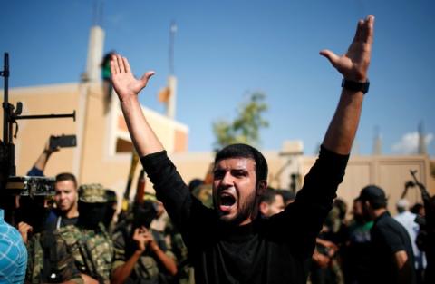A mourner reacts as Palestinian Islamic Jihad militants hold their weapons while taking part in the funeral of their comrade in the central Gaza Strip, October 31, 2017. PHOTO BY REUTERS/Suhaib Salem