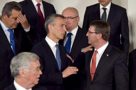 NATO Secretary General Jens Stoltenberg (C) and U.S. Secretary of Defense Ash Carter (R) chat after a family photo, following a meeting of the North Atlantic Council (NAC) in Defense Ministers session at the NATO headquarters in Brussels, Belgium June 24, 2015. PHOTO BY REUTERS/Eric Vidal