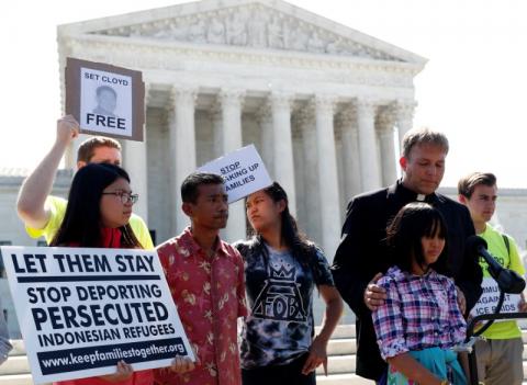 Naomi Lien,10, is comforted by Pastor Seth Kaper-Dale as she they react with other immigration rights proponents outside the U.S. Supreme Court after the Court upheld U.S. President Donald Trump's travel ban targeting several Muslim-majority countries, in Washington, U.S., June 26, 2018. PHOTO BY REUTERS/Leah Millis