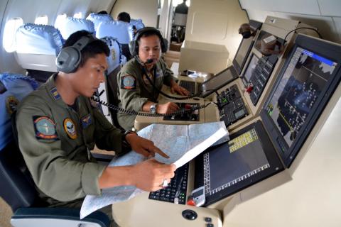 Two members of the Indonesian Navy's Tactical Commanding Operator (TACCO) help with the search for AirAsia flight QZ 8501 on board a CN235 aircraft over Karimun Java, in the Java Sea December 28, 2014. PHOTO BY REUTERS/Eric Ireng