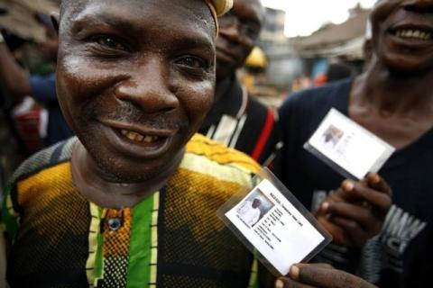 Nigerian voters show off their identity cards while lining up to vote in the neighbourhood of Isale-Eko in in a file photo. PHOTO BY REUTERS/Finbarr O'Reilly