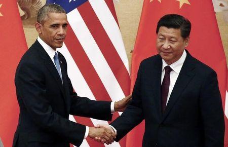 U.S. President Barack Obama (L) shakes hands with China's President Xi Jinping in front of U.S. and Chinese national flags during a joint news conference at the Great Hall of the People in Beijing, November 12, 2014. PHOTO BY REUTERS/Petar Kujundzic