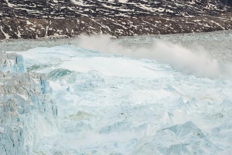 Ocean water is pushed up by the bottom of a pinnacle iceberg as it falls back during a large calving event at the Helheim glacier near Tasiilaq, Greenland, June 22, 2018. PHOTO BY REUTERS/Lucas Jackson