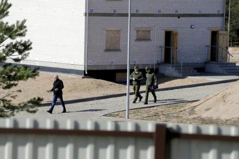 Lithuanian army officers and specialist walk past building in the construction site of newly built training facilities for urban warfare in Pabrade, Lithuania, April 28, 2016. PHOTO BY REUTERS/Ints Kalnins