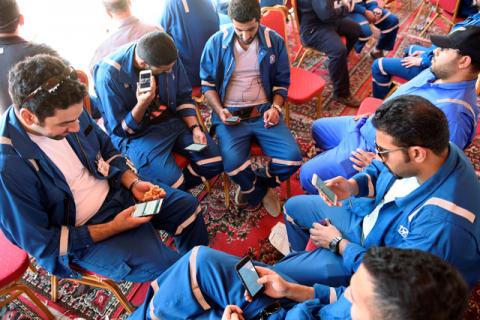 Kuwait Oil and Petrochemical Industries Union workers sit with their cellphones on the first day of an official strike over public sector pay reforms, in Ahmadi, Kuwait, April 17, 2016. PHOTO BY REUTERS/Stephanie McGehee