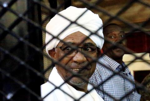 Sudanese former president Omar Hassan al-Bashir smiles inside a cage as he faces corruption charges in a court in Khartoum, Sudan, August 31, 2019. PHOTO BY REUTERS/Mohamed Nureldin Abdallah