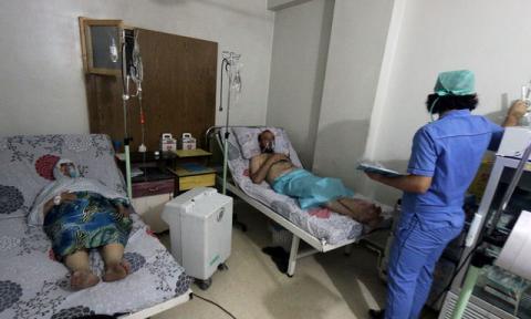 Civilians breathe through an oxygen mask at al-Quds hospital, after a hospital and a civil defence group said a gas, what they believed to be chlorine, was dropped alongside barrel bombs on a neighbourhood of the Syrian city of Aleppo, Syria, early August 11, 2016. PHOTO BY REUTERS/Abdalrhman Ismail