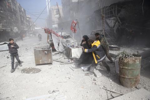 People walk on rubble of damaged buildings after an airstrike in the besieged town of Douma in eastern Ghouta in Damascus, Syria, February 7, 2018. PHOTO BY REUTERS/ Bassam Khabieh