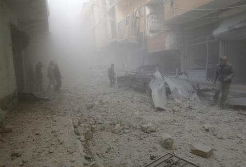 People walk on rubble as they inspect a site hit by what activists said were airstrikes by forces loyal to Syria's President Bashar al-Assad in Raqqa, eastern Syria, which is controlled by the Islamic State, November 27, 2014. PHOTO BY REUTERS/Nour Fourat