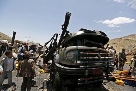 People gather at the site of a Saudi-led air strike that targeted a truck loaded with cooking oil canisters in Nqeel Yaslih near Yemen's capital Sanaa, August 17, 2015. PHOTO BY REUTERS/Khaled Abdullah