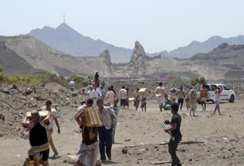 People carry ammunition boxes they took from army depots in Yemen's southern port city of Aden, March 27, 2015. PHOTO BY REUTERS/Anees Manousr