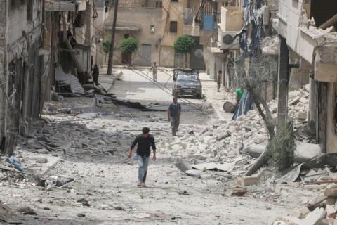 People walk on the rubble of damaged buildings after an airstrike in the rebel held area of Aleppo's Baedeen district, Syria, May 3, 2016. PHOTO BY REUTERS/Abdalrhman Ismail