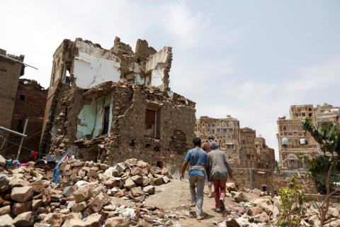 People walk past a house destroyed by an air strike in the old quarter of Sanaa, Yemen, August 8, 2018. PHOTO BY REUTERS/Khaled Abdullah