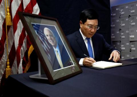 Vietnam's Deputy Prime Minister and Foreign Minister Pham Binh Minh writes in a condolence book near a portrait of U.S. Senator John McCain (R-AZ) about his death at the U.S. embassy in Hanoi, Vietnam, August 27, 2018. PHOTO BY REUTERS/Kham