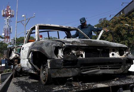 An Afghan policeman inspects the wreckage of a car after a Taliban attack on a guesthouse in Kabul, May 27, 2015. PHOTO BY REUTERS/Omar Sobhani