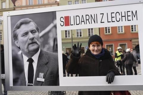A women poses next to a picture of former president Lech Walesa with the words "Solidarity with Lech" during a demonstration in Wroclaw, Poland, February 27, 2016. PHOTO BY REUTERS/Karolina Glowacka-Wolf