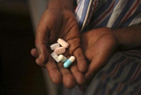 Nine-year-old Tumelo shows off antiretroviral (ARV) pills before taking his medication at Nkosi's Haven, south of Johannesburg, November 28, 2014. PHOTO BY REUTERS/Siphiwe Sibeko