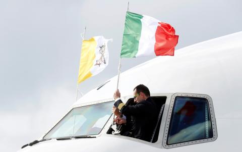 A pilot adjusts an Italian flag on the cockpit window, ahead of Pope Francis' departure for his visit to United Arabs Emirates, at Leonardo da Vinci-Fiumicino Airport in Rome, Italy, February 3, 2019. PHOTO BY REUTERS/Remo Casilli