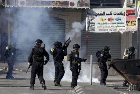 An Israeli border policeman fires teargas during clashes with Palestinian stone-throwers in the Shuafat refugee camp near Jerusalem, September 18, 2015. PHOTO BY REUTERS/Ammar Awad