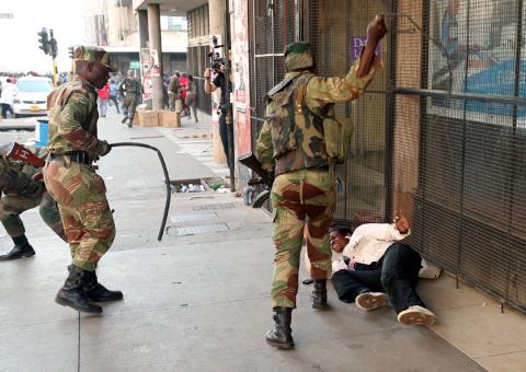 Soldiers beat a supporter of the opposition Movement for Democratic Change party of Nelson Chamisa outside the party's headquarters as they await the results of the general elections in Harare, Zimbabwe, August 1, 2018. PHOTO BY REUTERS/Mike Hutchings