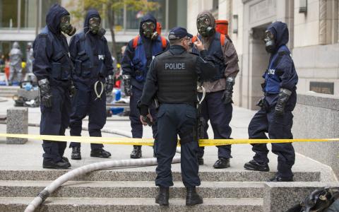 Police officers wearing gas masks stand in the financial district during a mock "crisis response" exercise in Toronto, October 26, 2014. PHOTO BY REUTERS/Mark Blinch