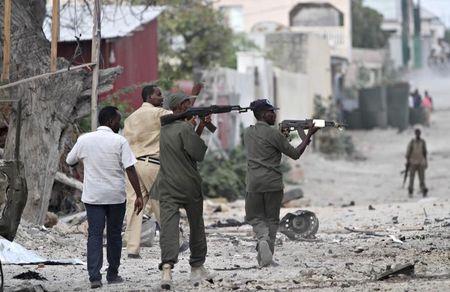 Somali police hold their weapons as they walk outside the Maka Al-Mukarama hotel during an Islamist group al Shabaab attack in the capital Mogadishu, March 27, 2015. PHOTO BY REUTERS/Feisal Omar