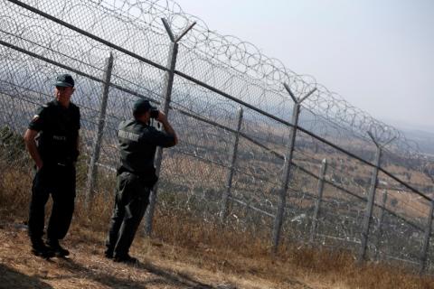 Bulgarian border policemen stand near the barbed wire fence constructed on the Bulgarian-Turkish border, near Lesovo, Bulgaria, September 14, 2016. PHOTO BY REUTERS/Stoyan Nenov