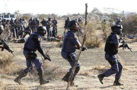 Policemen react after firing shots at protesting miners outside a South African mine in Rustenburg, 100 km (62 miles) northwest of Johannesburg, August 16, 2012. PHOTO BY REUTERS/Siphiwe Sibeko