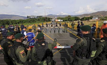 Colombian policemen stand guard in front of the border with Venezuelan policemen Bolivarianos near Villa del Rosario village, August 27, 2015. PHOTO BY REUTERS/Jose Miguel Gomez
