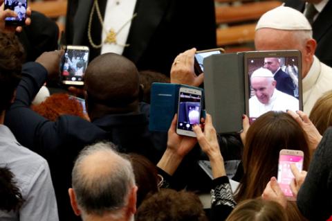 People take photos as Pope Francis attends a special audience with members of a volunteers association from Sardinia island in the Paul VI Hall at the Vatican, November 30, 2018. PHOTO BY REUTERS/Max Rossi