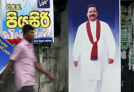 A man walks past a poster of Sri Lanka's former president Mahinda Rajapaksa ahead of a general election, in Galle, August 14, 2015. PHOTO BY REUTERS/Dinuka Liyanawatte