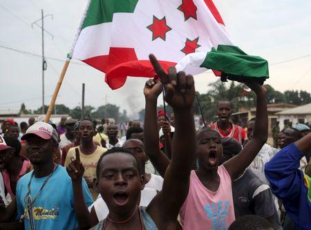People carry a Burundi flag during a protest against President Pierre Nkurunziza and his bid for a third term, in Bujumbura, Burundi, May 25, 2015. PHOTO BY REUTERS/Goran Tomasevic