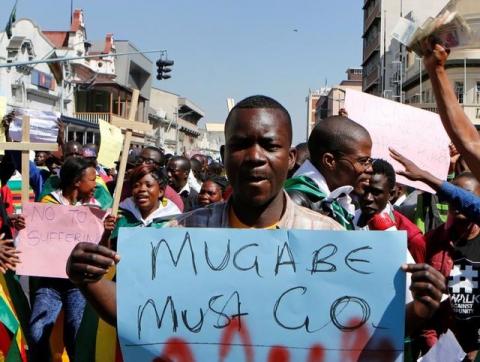 Zimbabweans hold placards during a protest against President Robert Mugabe government's handling of the economy in Harare, Zimbabwe, August 3, 2016. PHOTO BY REUTERS/Philimon Bulawayo
