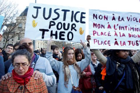 A demonstrator holds up a placard which says "Justice for Theo" to protest against police brutality after a young black man, 22-year-old youth worker named Theo, was severely injured during his arrest earlier this month in Bobigny, as people gather at a demonstration in Paris, France, February 18, 2017. PHOTO BY REUTERS/Charles Platiau