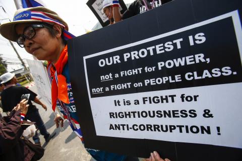 An anti-government protester holds a placard during a rally in Bangkok 