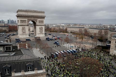 PARIS (Reuters) - Anti-government protesters faced off with French riot police in Paris on Saturday, hurling projectiles, torching cars and vandalizing shops and restaurants in a fourth weekend of unrest that has shaken President Emmanuel Macron's authority.  Police used tear gas, water cannon and horses to charge protesters on roads fanning out from the Champs Elysees boulevard, but encountered less violence than a week ago, when the capital witnessed its worst unrest since the 1968 student riots.  As nigh