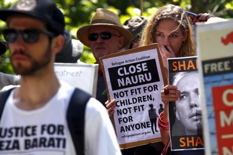 Protesters react as they hold placards and listen to speakers during a rally in support of refugees in central Sydney, Australia, October 19, 2015. PHOTO BY REUTERS/David Gray
