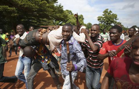 Protesters carry a man who was shot by French soldiers after French troops opened fire at protesters blocking a road in Bambari, Central African Republic