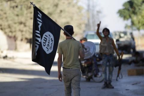A rebel fighter takes away a flag that belonged to Islamic State militants in Akhtarin village, after rebel fighters advanced in the area, in northern Aleppo Governorate, Syria, October 7, 2016. PHOTO BY REUTERS/Khalil Ashawi