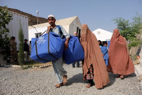 An Afghan family, who were living as refugees in Pakistan, carries bundles of supplies at a humanitarian aid station in Torkham, Afghanistan, October 22, 2016. PHOTO BY REUTERS/Josh Smith