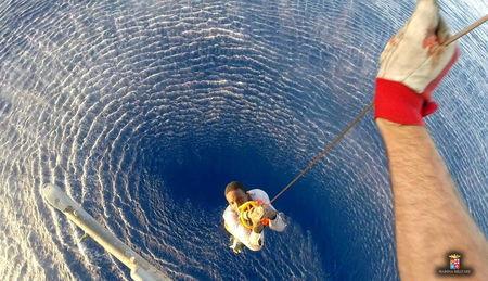 A migrant is rescued by an Italian Navy helicopter in the area where his boat sank in the Mediterranean Sea, August 11, 2015. PHOTO BY REUTERS/Italian Navy